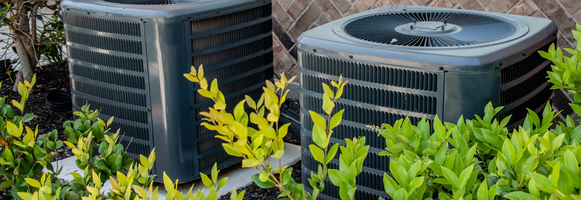 hvac units outside near a bush