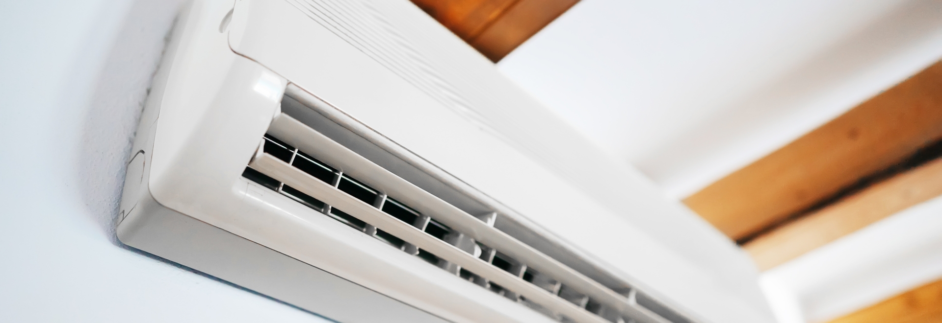 heat pump head on a wall with wooden beams on the ceiling