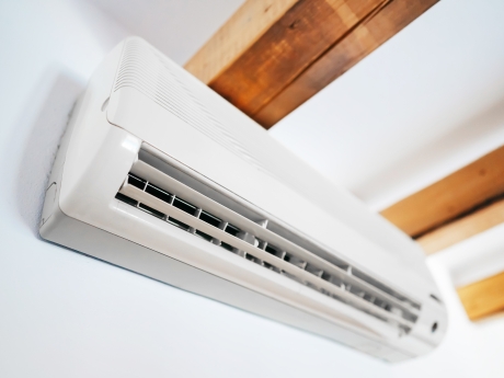 heat pump head on a wall with wooden beams on the ceiling